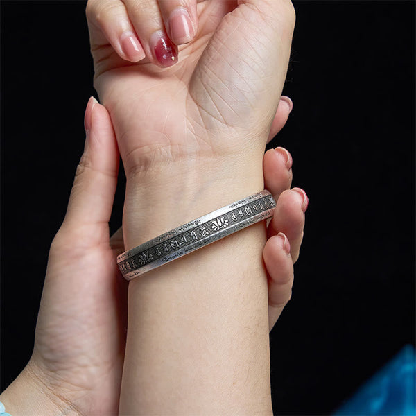Om Mani Padme Hum Silver Cuff – Worn on wrist showing engraved Tibetan mantra and lotus details, adjustable fit