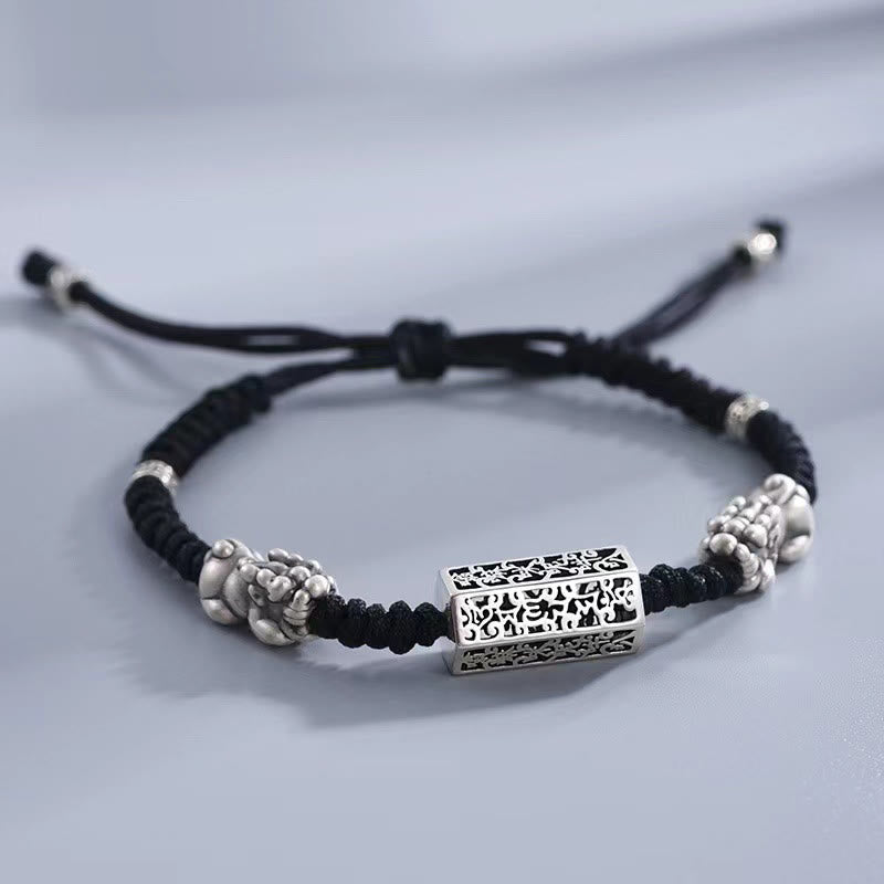 Tibetan PiXiu Bracelet – Black braided bracelet worn on wrist with silver PiXiu and engraved copper cylinder charm