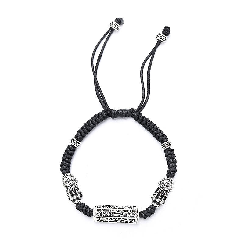 Tibetan PiXiu Bracelet – Isolated black braided bracelet with silver PiXiu and copper mantra cylinder on white