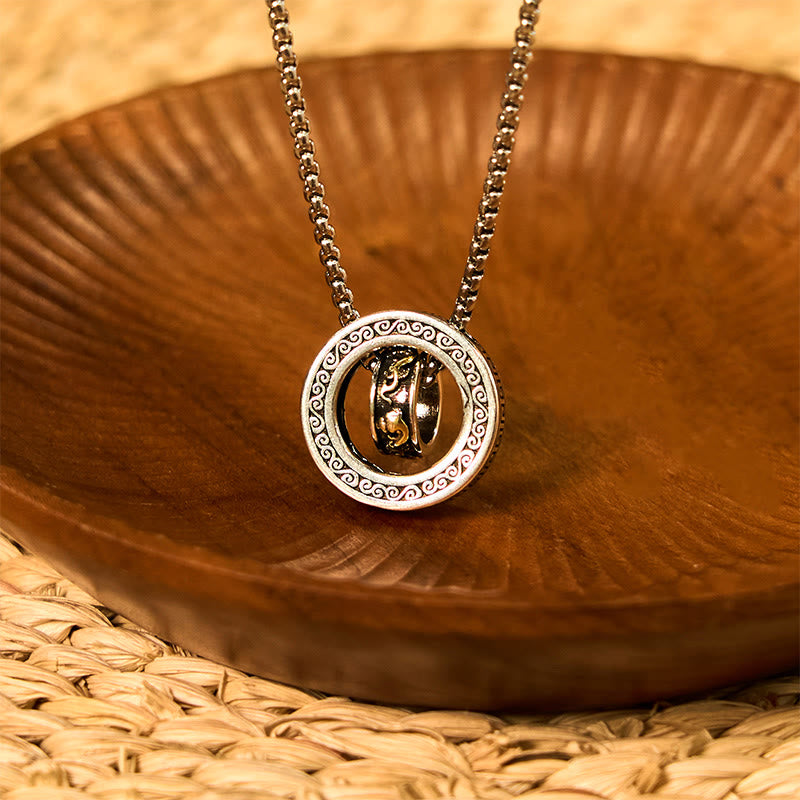 Double Ring PiXiu Necklace – Silver peace buckle pendant with golden PiXiu hanging over carved wooden bowl