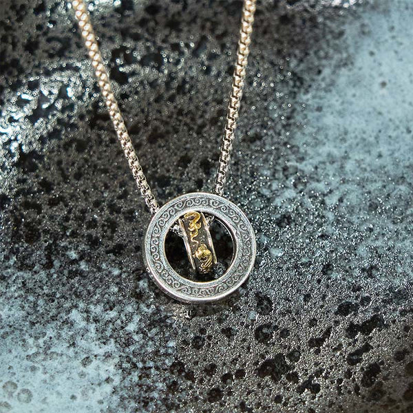 Double Ring PiXiu Necklace – Silver pendant with golden PiXiu on wet dark stone with water droplets, moody lighting