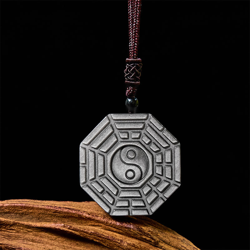 Silver Sheen Obsidian Bagua Yin Yang Pendant on black backdrop with braided cord, feng shui amulet