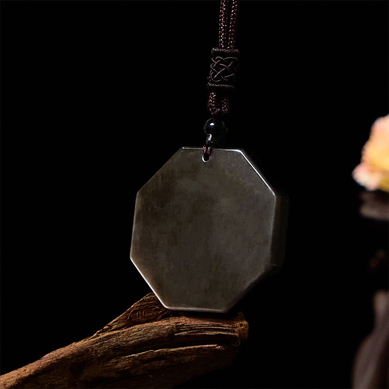 Silver Sheen Obsidian Bagua Yin Yang Pendant on driftwood with dark backdrop, side view detail