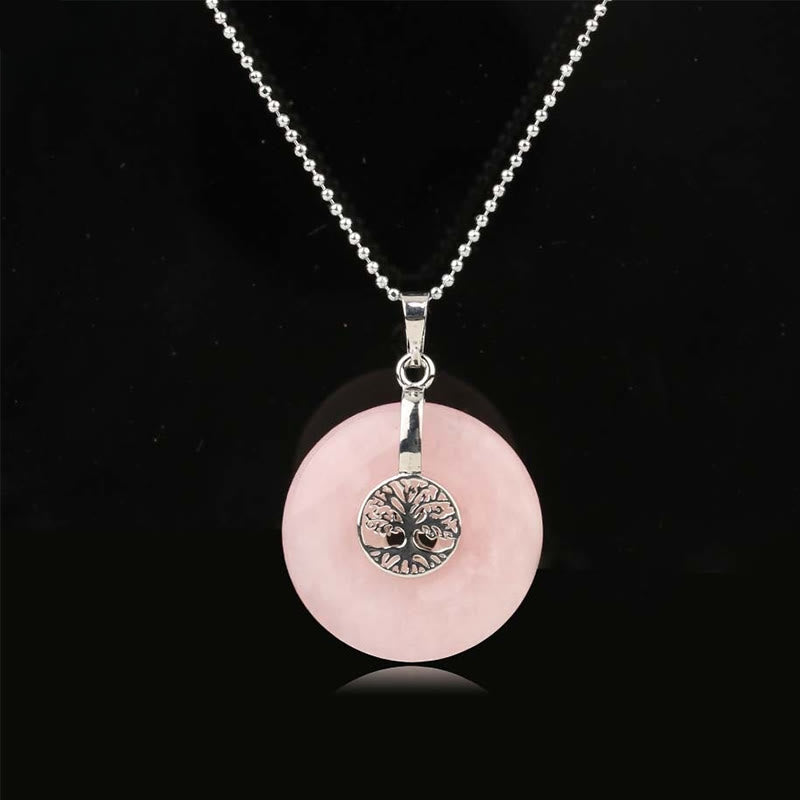 Tree of Life Crystal Necklace – rose quartz donut pendant on black background, frontal silver chain view