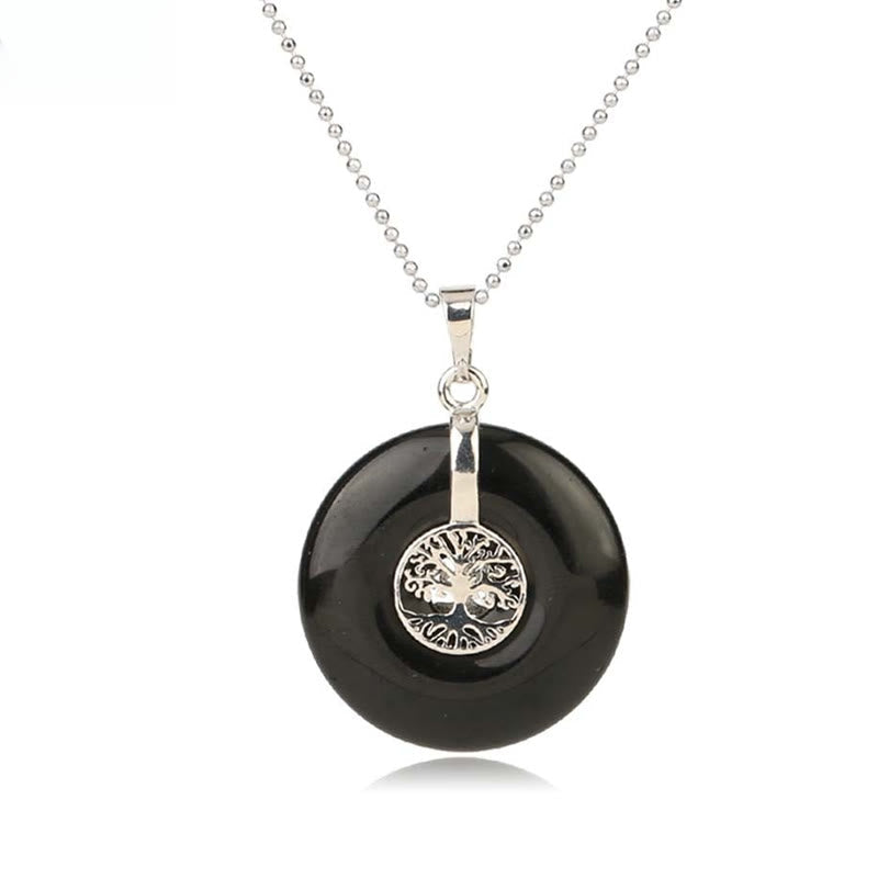 Tree of Life Crystal Necklace – black onyx donut pendant on white background, frontal silver chain view