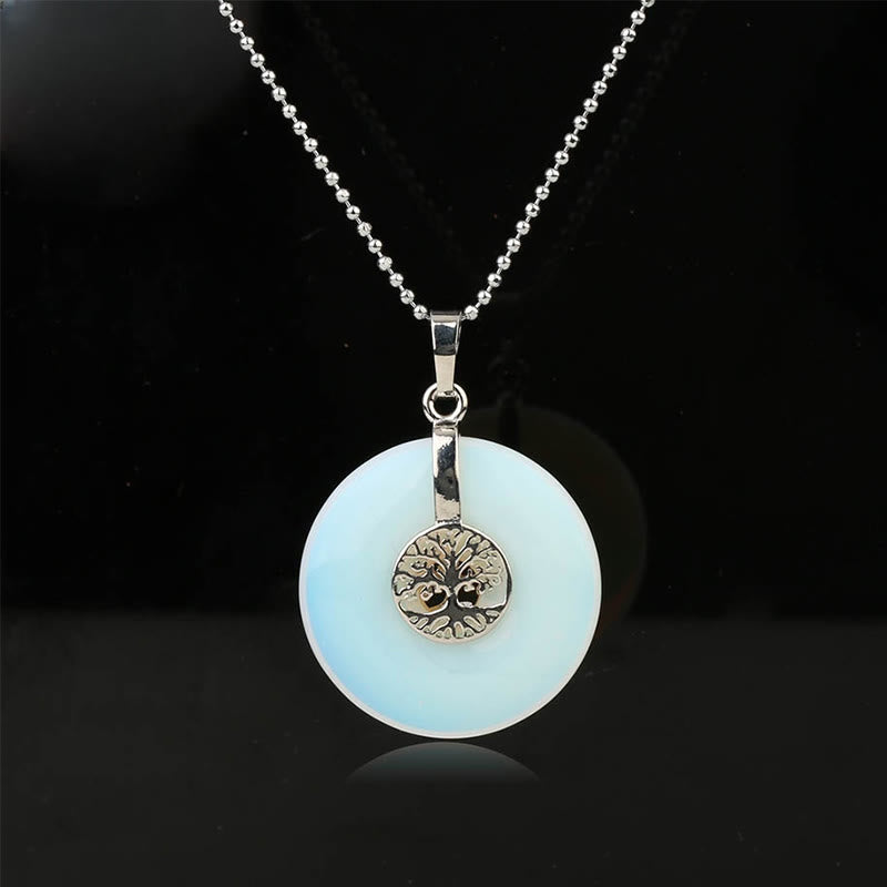 Tree of Life Crystal Necklace – opalite milky white donut pendant on black, frontal silver chain view
