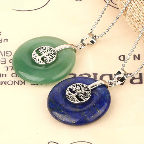 Tree of Life Crystal Necklace – aventurine and lapis lazuli pendants on cream paper, overhead angled view