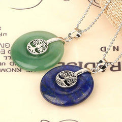 Tree of Life Crystal Necklace – aventurine and lapis lazuli pendants on cream paper, overhead angled view
