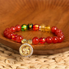 Red Agate Wealth Gods Bracelet – circular layout on woven mat with spinning prayer wheel pendant, prosperity