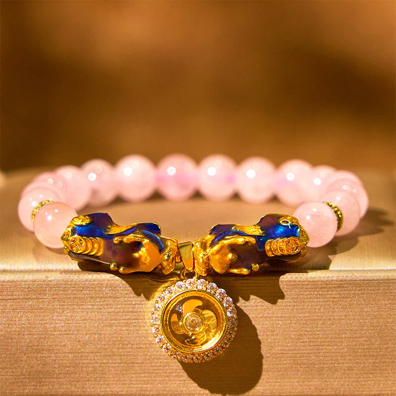 Pink crystal bracelet with double PiXiu on gold satin, warm lighting