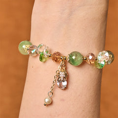 Green Strawberry Quartz Bracelet – Wrist shot of green quartz beads with golden PiXiu charm and pearl dangle