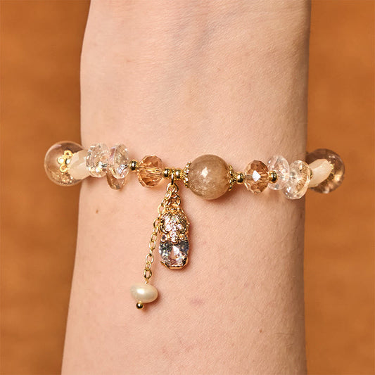 Citrine PiXiu Bracelet – Bracelet worn on wrist showing golden PiXiu with citrine beads and pearl charm, warm wood background