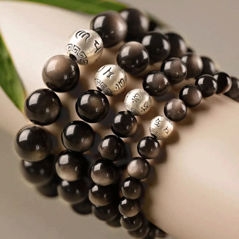 Silver Sheen Obsidian Bracelet – close up of coiled multi strand stack on display stand, grounding protection