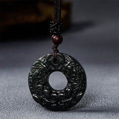 Black-green jade peace buckle pendant on grey textured background