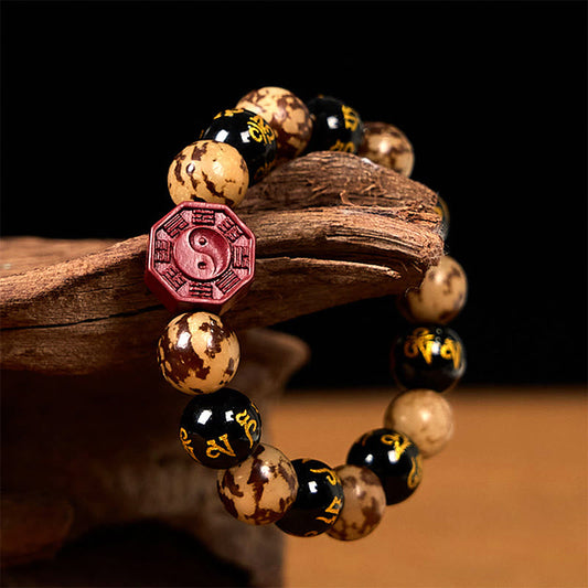 Bodhi Seed Bagua Yin Yang Bracelet – Draped on driftwood against black backdrop, spiritual bead bracelet