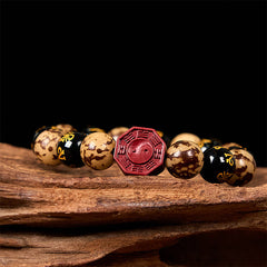 Bodhi Seed Bagua Yin Yang Bracelet – Close-up on textured wood, cinnabar bagua charm with trigram detail