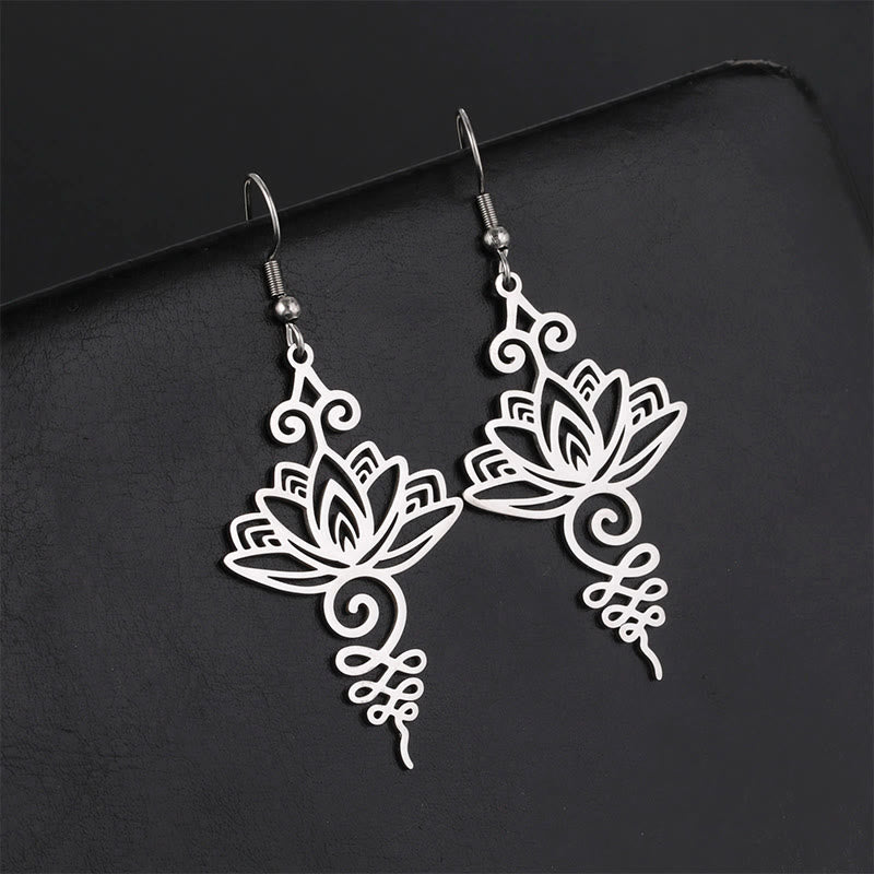 Hollow Lotus Stainless Steel Enlightenment Drop Earrings - silver openwork lotus with scrollwork, dark backdrop, zen style