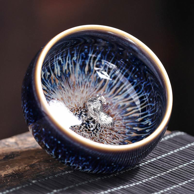 Jianzhan 12 Cup Set - cup with silver toad ornament, iridescent blue crystalline glaze on mat
