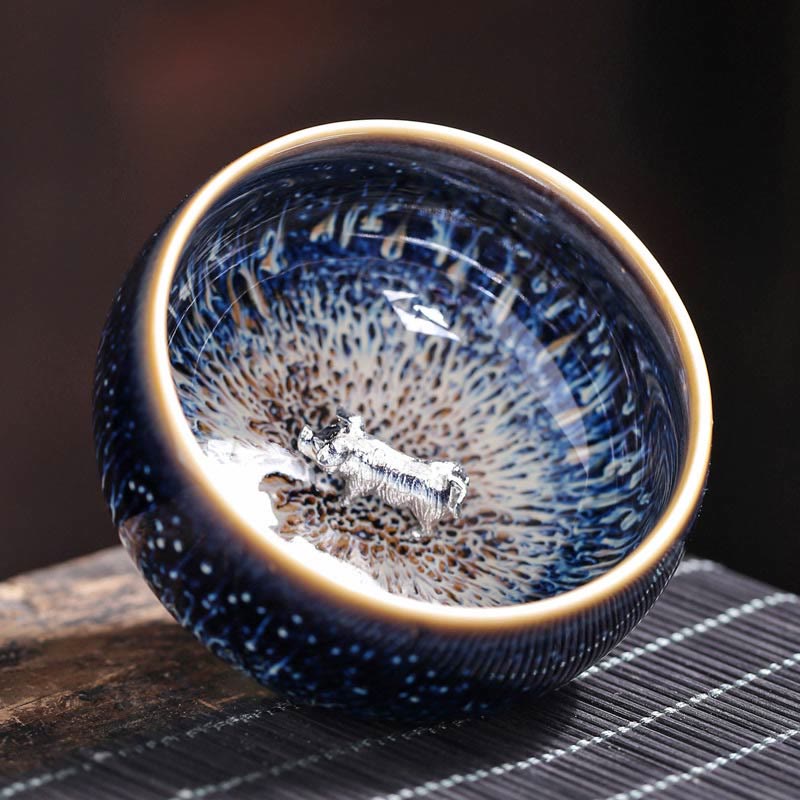 Jianzhan 12 Cup Set - bowl exterior with blue copper streaks on woven mat, hare's fur glaze