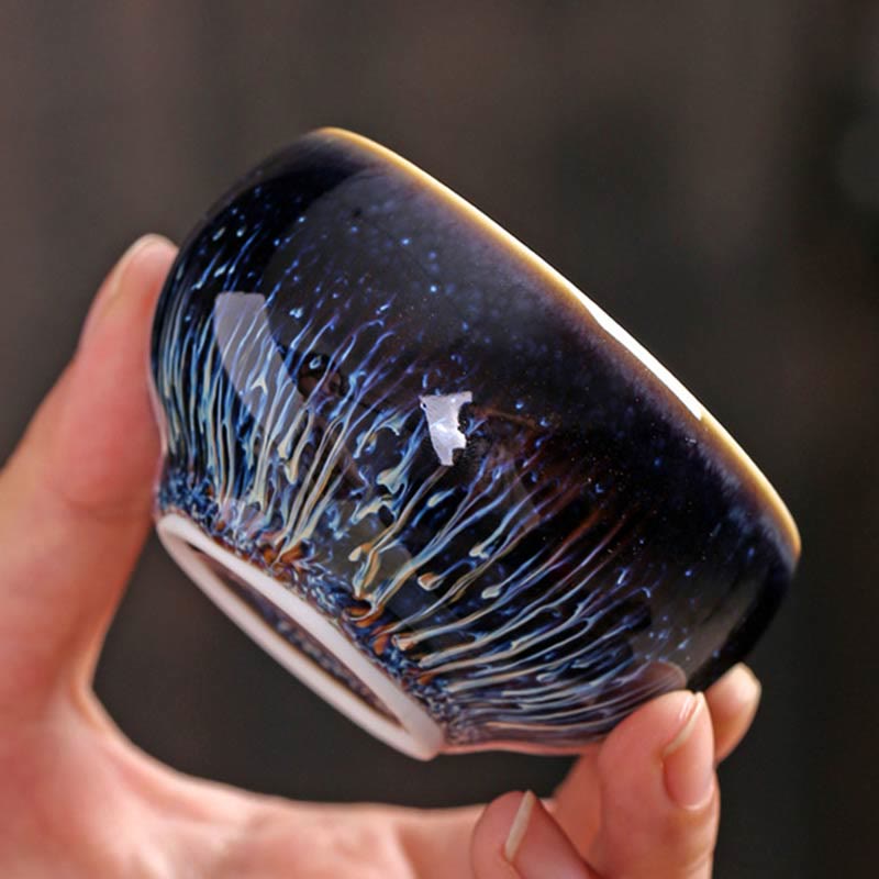 Jianzhan 12 Cup Set - bowl exterior with iridescent blue hare's fur streaks, held in hand