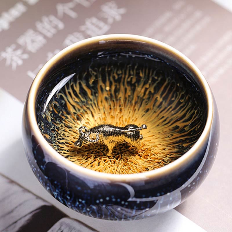 Jianzhan 12 Cup Set - bowl exterior showing blue hare's fur streaks, held in hand, dark bg
