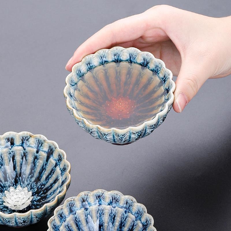 Jianzhan Lotus Ceramic Tea Cup filled with amber tea among two others, silver center, handmade