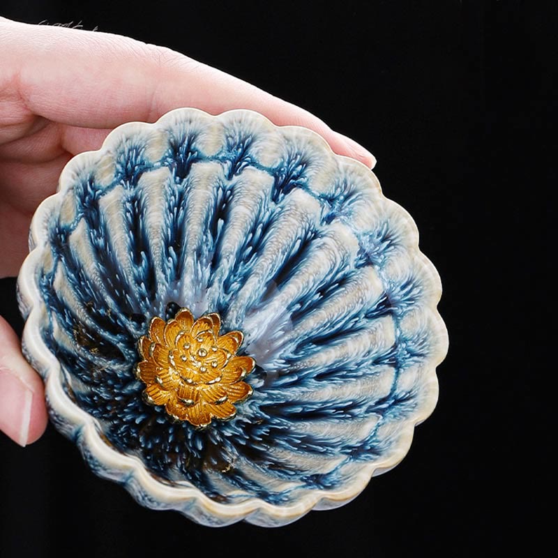 Jianzhan Lotus Ceramic Tea Cup held in hand revealing gold lotus detail and blue glaze, Kung Fu tea