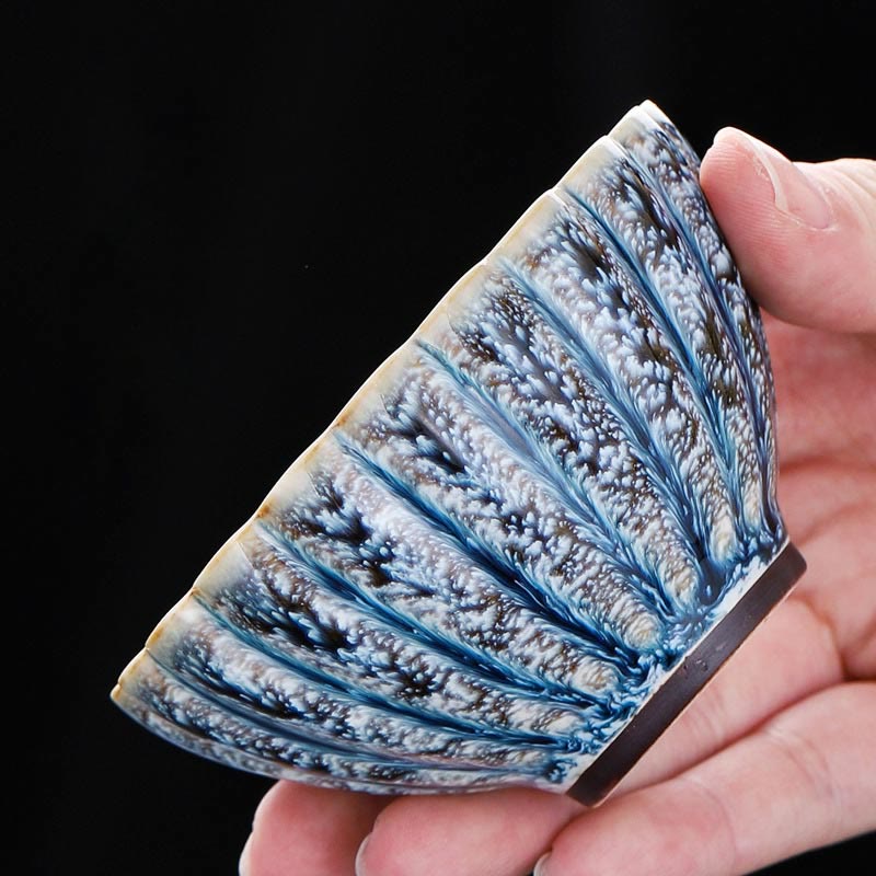 Jianzhan Lotus Ceramic Tea Cup side view held in hand showing crystalline blue glaze, handmade ceramic
