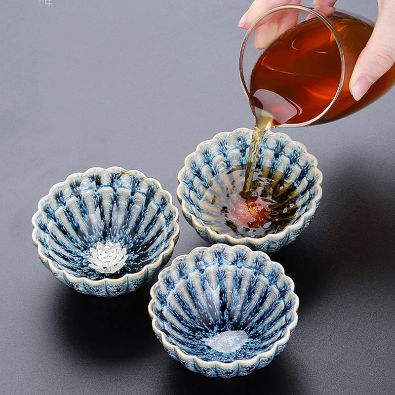 Jianzhan Lotus Ceramic Tea Cup with tea poured from glass pitcher, silver center, artisan