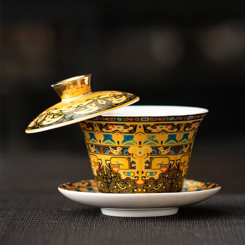 Dunhuang Ceramic Gaiwan Tea Set – Gold gaiwan lid ajar showing taotie bands, dark bokeh, Ornate Detail