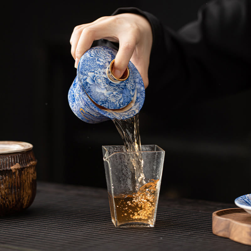 Dunhuang Ceramic Gaiwan Tea Set – Gaiwan pouring amber tea into glass pitcher, black studio, Active Pour