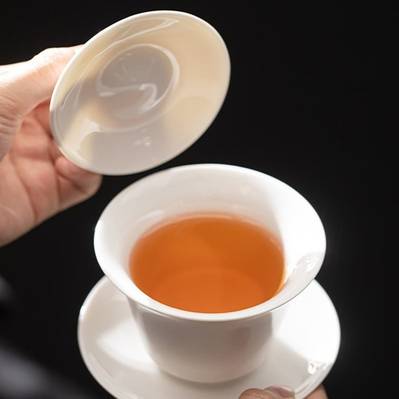 Dunhuang Ceramic Gaiwan Tea Set – White gaiwan with amber tea lid held above, Pure Simplicity