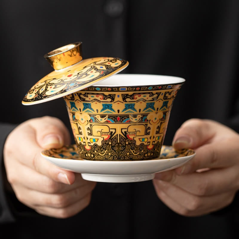 Dunhuang Ceramic Gaiwan Tea Set – Gold-ground gaiwan held in hands on black, taotie and cloud, Royal Display
