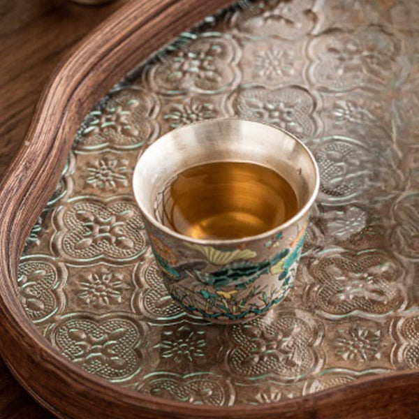 Fish Lotus Tea Cup – golden tea on aged silver tray with quatrefoil embossing, tea ceremony setting