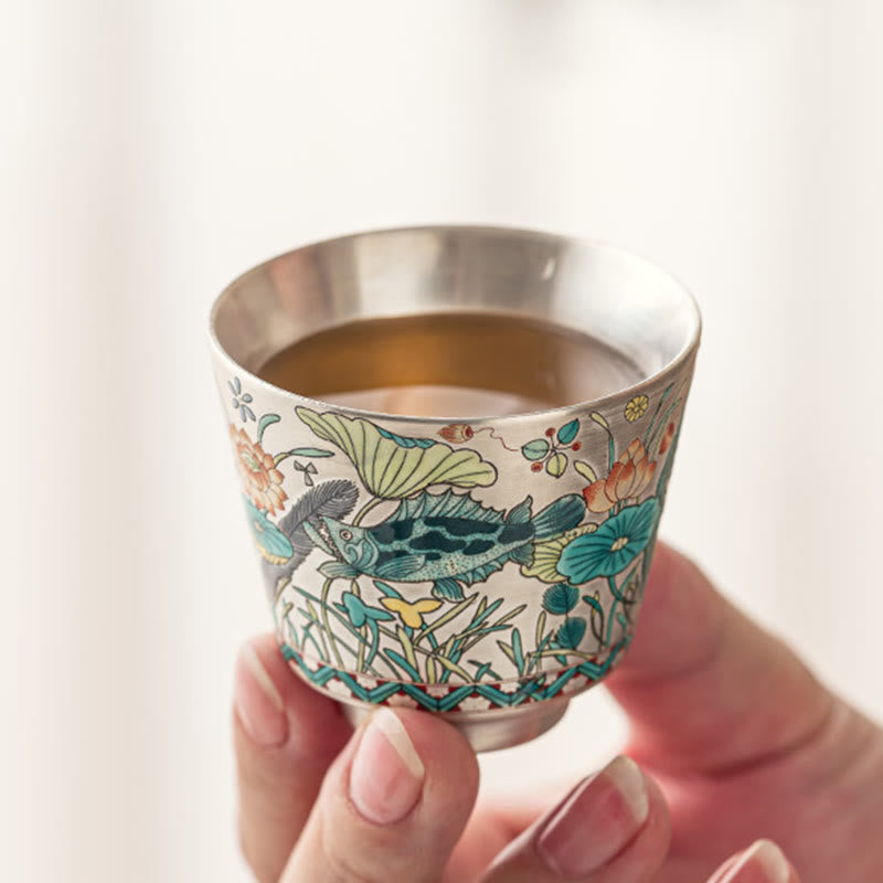 Fish Lotus Tea Cup – silver interior and enamel koi exterior held on white background, kung fu teacup