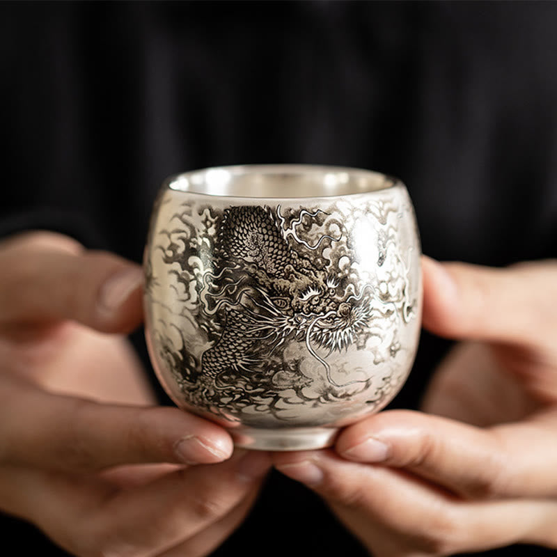 Ceramic Kung Fu Tea Cup Gift Set – Silver dragon cup held in both hands on black, Intimate Craft
