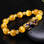 Yellow cat's eye beads with gold spacers and enamel PiXiu on black stone