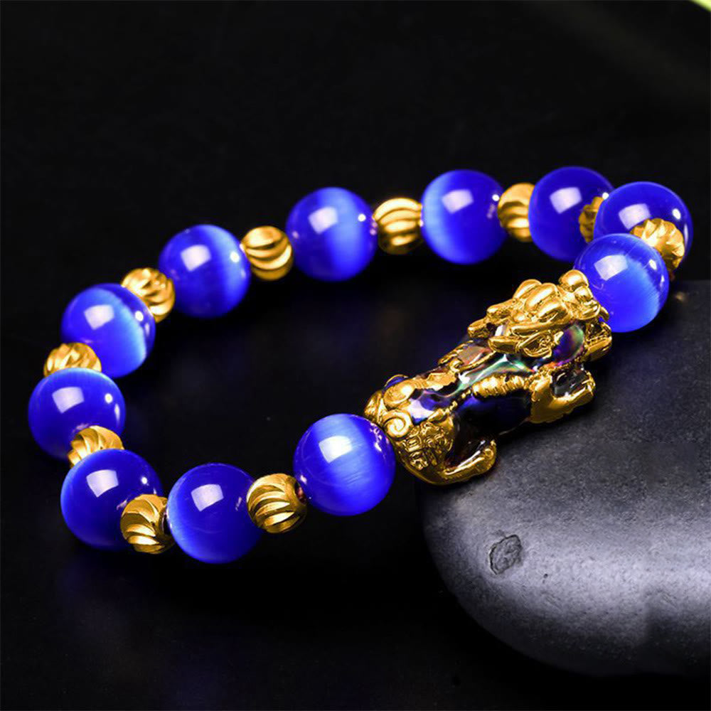 Blue cat's eye beads with gold spacers and enamel PiXiu on black stone