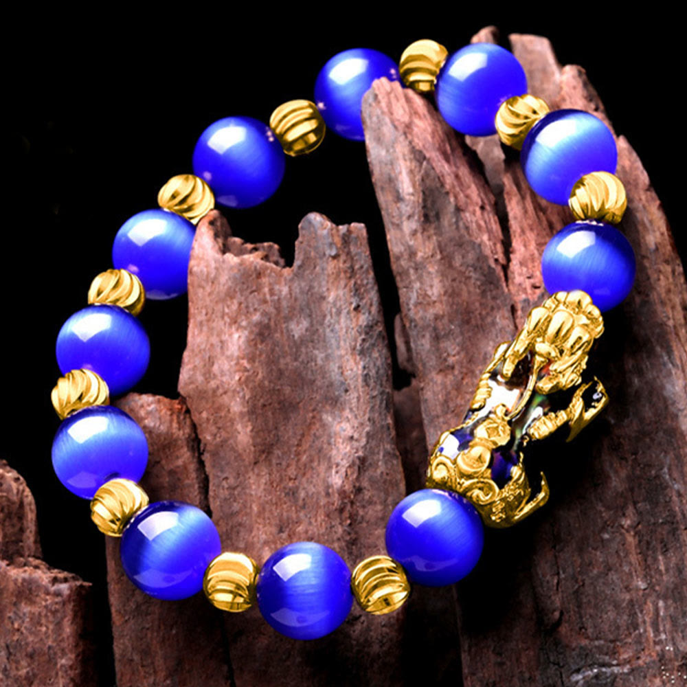 Blue cat's eye bracelet on dark wood, angled overhead view