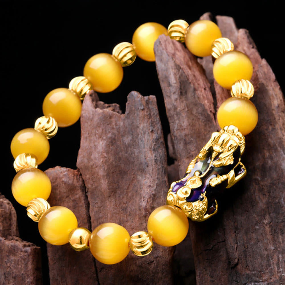 Yellow cat's eye bracelet on dark wood, angled overhead view