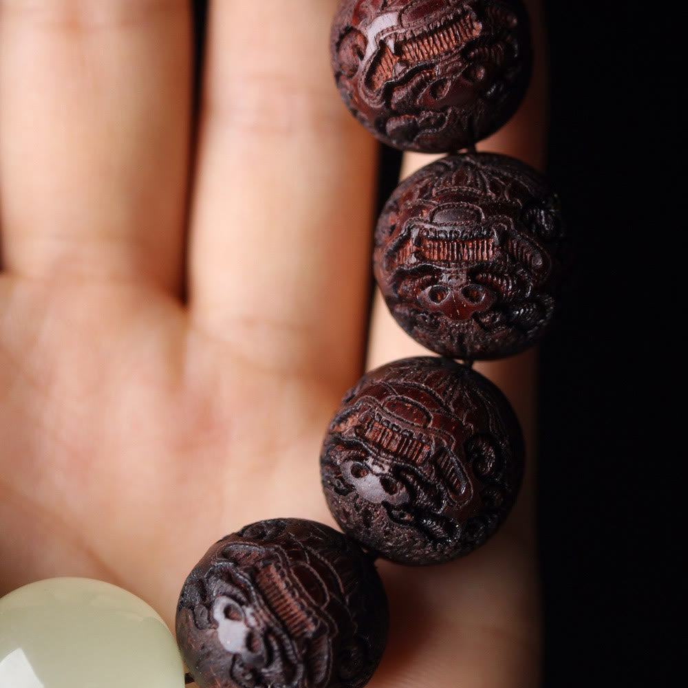Tibetan Rosewood Engraved Pixiu Warmth Healing Bracelet – carved Pixiu beads on palm side angle macro, protection good fortune