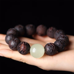 Tibetan Rosewood Engraved Pixiu Warmth Healing Bracelet – palm horizontal display on black background, carved rosewood bead detail
