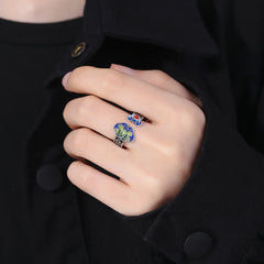 Lotus & Copper Coin Ruyi Adjustable Ring – worn on finger, cobalt blue and green cloisonne enamel on dark oxidized silver