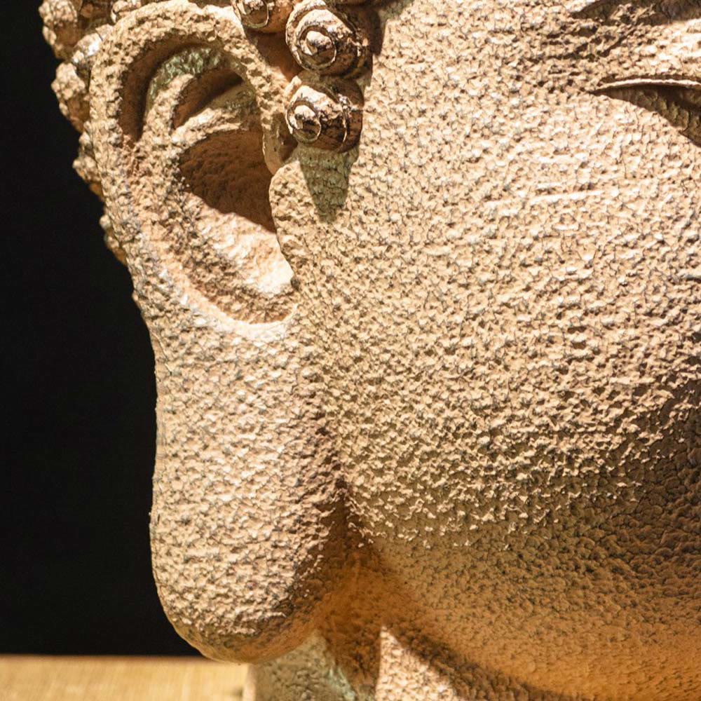 Meditating Buddha Head Statue – light and shadow on face creating peaceful ambiance