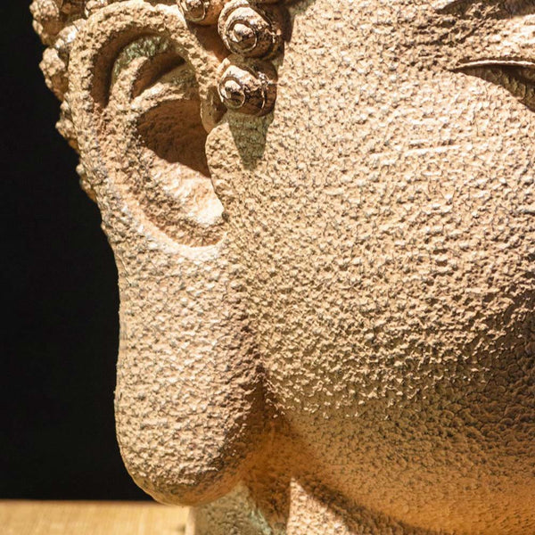 Meditating Buddha Head Statue – light and shadow on face creating peaceful ambiance