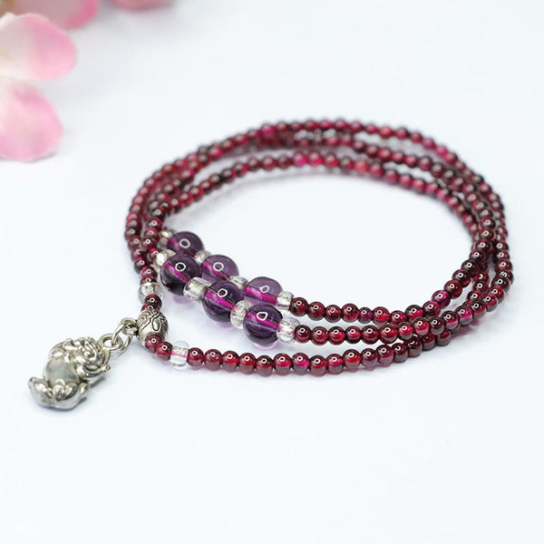 Natural Garnet PiXiu Elephant Abacus Lucky Bag Bracelet – garnet beads with Pi Xiu talisman on white background, healing feng shui
