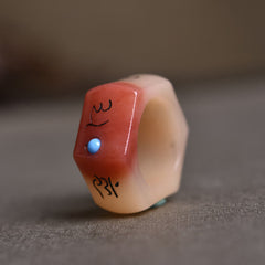 Camel Bone Om Mani Padme Hum Ring - Oblique view of carved band with coral face and turquoise accent, bone ring
