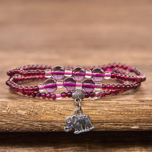 Natural Garnet PiXiu Elephant Abacus Lucky Bag Bracelet – garnet purple beads on wood surface with elephant pendant, feng shui wealth