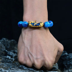 Colorful Sea Willow Pixiu Bracelet – worn on wrist with rocky background, fortune bracelet
