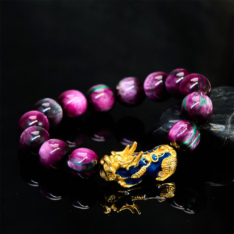 Purple sea willow bracelet with gold PiXiu on reflective black surface